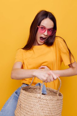 İyimser genç kadın hasır çanta elinde pembe gözlük izole edilmiş arka plan