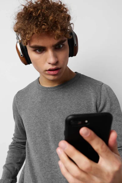 Joven guapo mirando los auriculares del teléfono de moda Estilo de vida inalterado —  Fotos de Stock