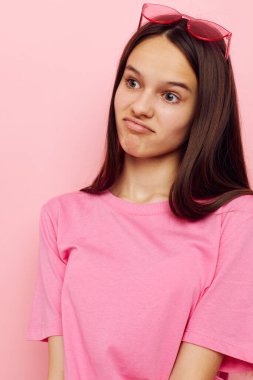 fotoğraf güzel kadın pembe gözlük ve tişört el hareketi pembe arka plan