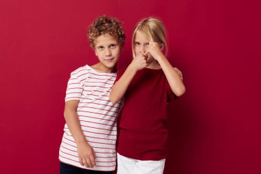 Erkek ve kız gülümsüyor ve renkli arka planda günlük kıyafetlerle poz veriyorlar.