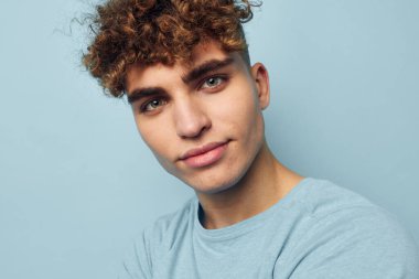 Şişirilmiş vücudu değişmemiş, mavi tişörtlü çekici bir adam.