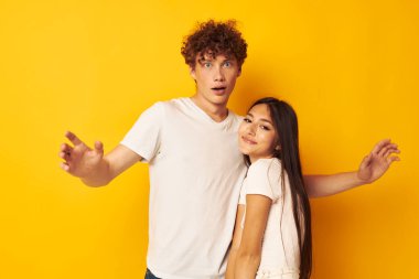 Tatlı, genç bir çift beyaz tişörtlerle birbirlerine sarılıyorlar. Arka planda bir değişiklik yok.