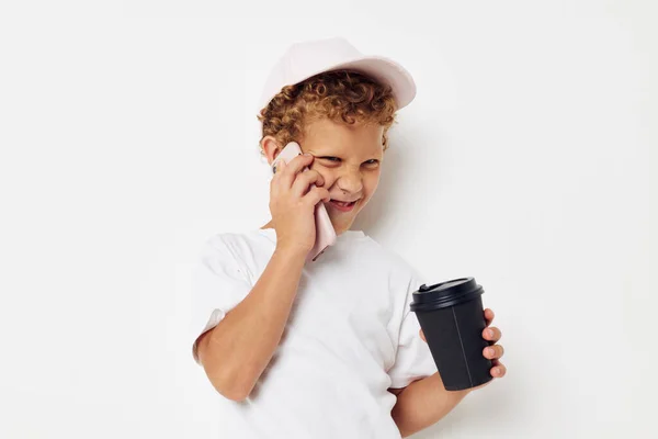 Foto retrato encaracolado menino que tipo de bebida é o telefone na mão comunicação isolado fundo inalterado — Fotografia de Stock