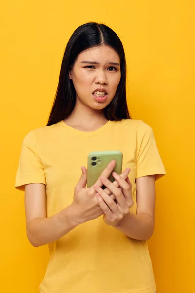 ポートレートアジアの美しい若い女性の電話通信楽しい使用黄色の背景変更なし — ストック写真