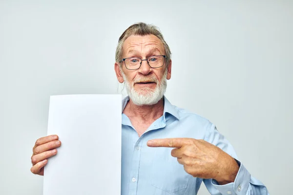 Старший седовласый мужчина держит лист бумажного копировального пространства на изолированном фоне — стоковое фото