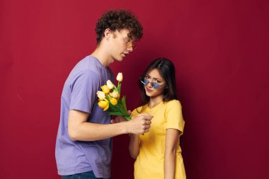 Sevimli genç çift çiçek buketi eğlenceli kırmızı arka plan değiştirilmemiş