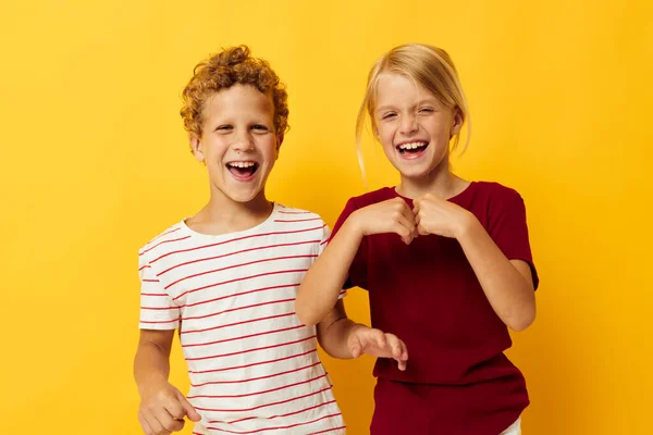 Mignons enfants d'âge préscolaire debout côte à côte posant les émotions de l'enfance fond jaune — Photo