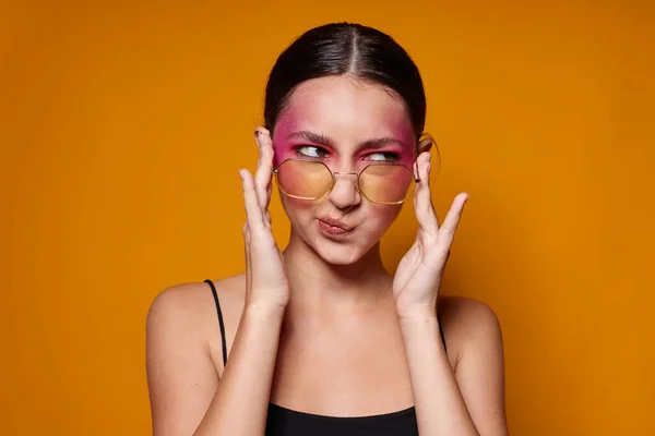 Vacker kvinna mode glasögon rosa ansikte makeup poserar attraktiv look isolerad bakgrund oförändrad — Stockfoto