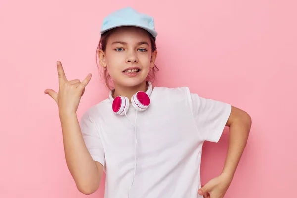 Ładna młoda dziewczyna słuchawki w białym t-shirt i czapka Styl życia bez zmian — Zdjęcie stockowe
