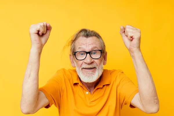 Portrét šťastného staršího muže s šedým vousem v brýlích žluté pozadí — Stock fotografie