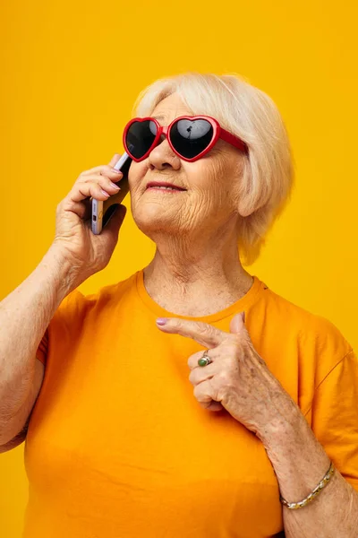 Elderly woman in dark glasses talking on the phone close-up emotions — Stock Photo, Image