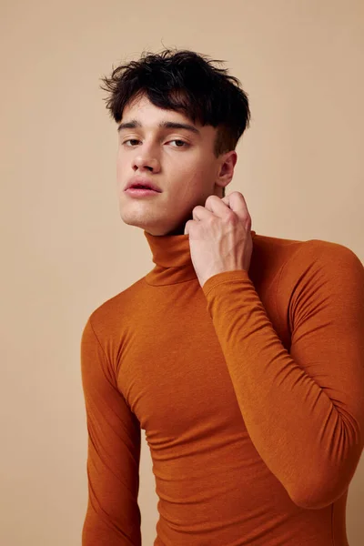 Молодий чоловік позує в коричневому светрі впевненість у собі модний світлий фон незмінний — стокове фото