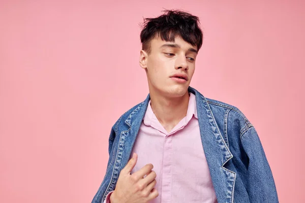 Mladý muž módní účes pózování oblečení džínové bundy moderní styl růžové pozadí beze změny — Stock fotografie