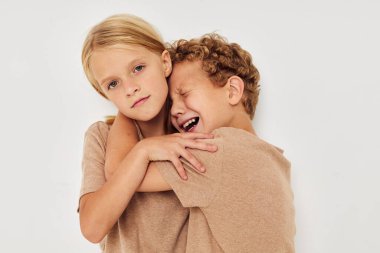 Küçük oğlan ve kız ellerini birleştirip el kol hareketleri yapıyorlar.