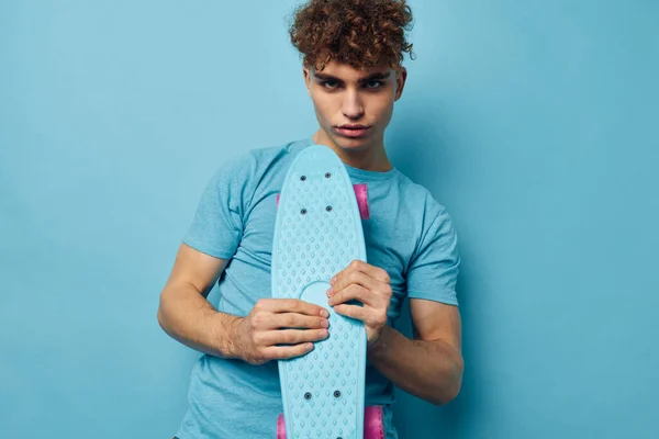 Красивий хлопець скейтборд в руці в синіх футболках Стиль життя незмінний — стокове фото