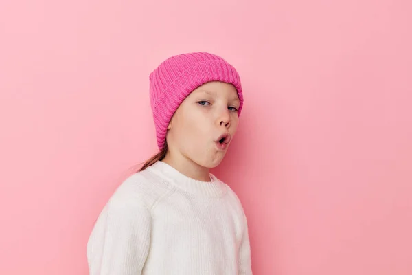 Маленькая девочка розовая шляпа на голове, позируя розовый фон — стоковое фото