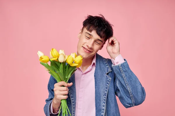 노란 꽃을 선물로 주는 멋진 남자의 부케 변경되지 않은 핑크 색 배경 — 스톡 사진