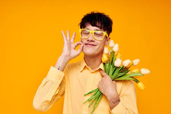 Photo of romantic young boyfriend give flowers wear spectacles yellow shirt Lifestyle unaltered Immagine Stock