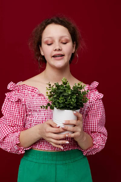Donna in possesso di un vaso da fiori in mano posa primo piano inalterato Immagini Stock Royalty Free