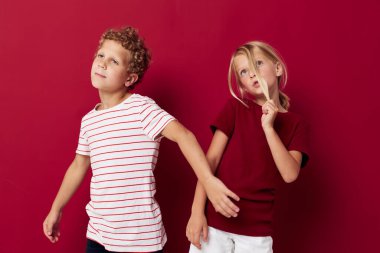 Küçük çocukların duyguları günlük kıyafetleriyle yan yana durur. Kırmızı arka plan değişmez.