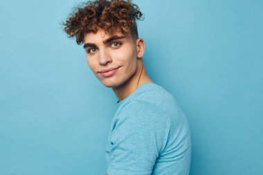 Şişirilmiş vücudu değişmemiş, mavi tişörtlü çekici bir adam.