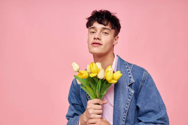 Портрет молодого чоловіка букет жовтих квітів подарунок свято елегантний стиль рожевий фон незмінний — стокове фото