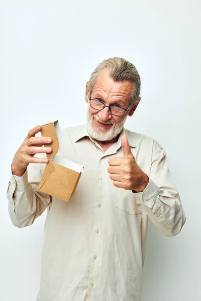 Uomo anziano con una scatola in mano in studio Fotografia Stock