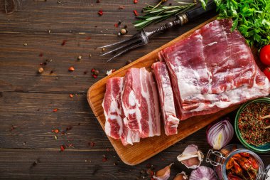 Tahtada yağlı pastırma. Sarımsak ve baharatlı domuz pastırması, ev yapımı domuz yağı, kesme tahtasında dilimler. Domuz eti..