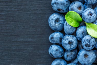 Olgun tatlı yaban mersinine su damlası. Metnin için fotokopi alanı olan taze yabanmersini arkaplanı. Vejetaryen ve vejetaryen kavramı. Yaban mersinli böğürtlenlerin makro dokusu. Yaban mersinli dokular kapanıyor.