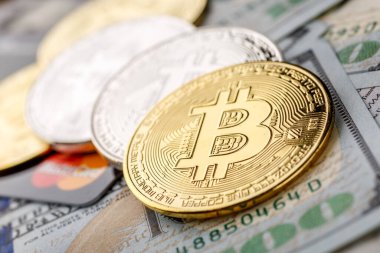 Altın Bitcoin banknotların üzerinde yatıyor. Yeni sanal para. Şifreli para birimi üst görünümü. 100 dolarlık banknotlarda gerçek bitcoin paraları. Değiş tokuş, reklam. çevrimiçi iş kavramı.