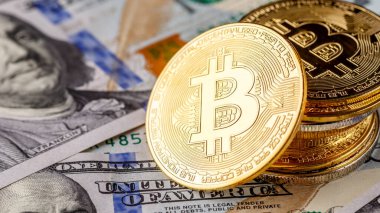 Altın Bitcoin banknotların üzerinde yatıyor. Yeni sanal para. Şifreli para birimi üst görünümü. 100 dolarlık banknotlarda gerçek bitcoin paraları. Değiş tokuş, reklam. çevrimiçi iş kavramı.