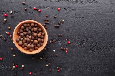 Bir biber seti. Farklı tip biber kolajı, siyah, beyaz, pembe ve tüm baharatlı biber, kurutulmuş kırmızı biber. Üst görünüm. Siyah bir arka planda. Metnin için boş yer.