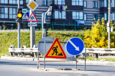 Yol işaretleri! Kamyonlar ve trafik işaretleri ile yol çalışmaları. Yol çalışmaları trafik işaretleri ve trafik konilerinin saptırma erişimini engelliyor; engeller ve trafik işaretleri.