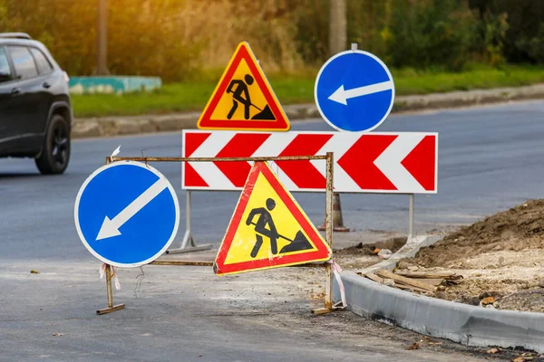 Yol işaretleri! Kamyonlar ve trafik işaretleri ile yol çalışmaları. Yol çalışmaları trafik işaretleri ve trafik konilerinin saptırma erişimini engelliyor; engeller ve trafik işaretleri.