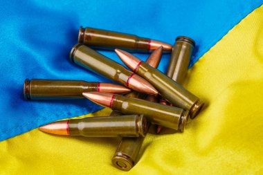 7.62 mm 'lik tüfek mermileri. Ukrayna bayrağı, UA. Mavi ve sarı renkler. Ordu üniformasında Ukrayna arması. Savaşı durdurun. Vatanseverlik. Yakın çekim, arkaplan