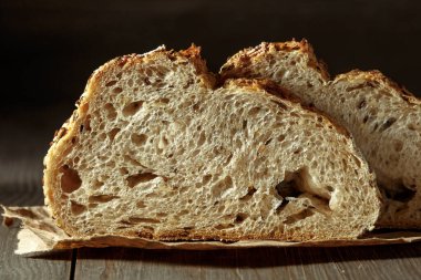 Ekmek, kırsal ahşap arka planda dilimlenmiş geleneksel ekşi ekmek. Geleneksel mayalanmış ekmek pişirme yöntemleri kavramı. Sağlıklı yemek..