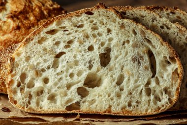 Ekmek, kırsal ahşap arka planda dilimlenmiş geleneksel ekşi ekmek. Geleneksel mayalanmış ekmek pişirme yöntemleri kavramı. Sağlıklı yemek..