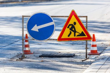 Yol işaretleri! Kamyonlar ve trafik işaretleri ile yol çalışmaları. Yol çalışmaları trafik işaretleri ve trafik konilerinin saptırma erişimini engelliyor; engeller ve trafik işaretleri.