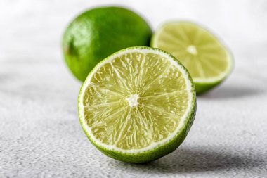 İkiye bölünmüş yeşil kireç ve beyaz arka planda izole edilmiş dilimler. Sağlıklı yeşil gıdalar - alternatif tıp vitaminler, besinler ve insan refahı için süper yiyecekler içeren dengeli bir diyet içerir..