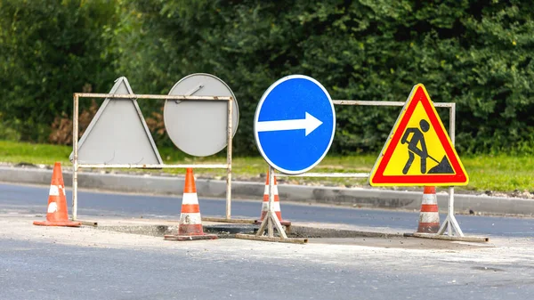 Yol işaretleri! Kamyonlar ve trafik işaretleri ile yol çalışmaları. Yol çalışmaları trafik işaretleri ve trafik konilerinin saptırma erişimini engelliyor; engeller ve trafik işaretleri.