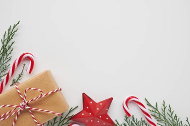 Hediye ile Noel köşe düzenleme, kozalaklı dallar ve beyaz arka planda süslemeler