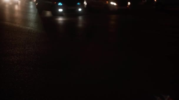 Auta pohybující se ve večerních hodinách osvětlují texturu silnice světlomety — Stock video