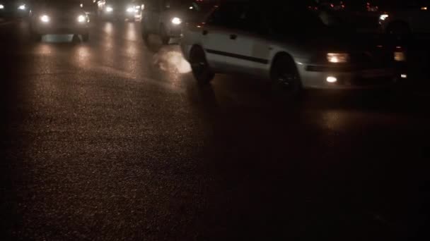 Abendstraße beleuchtet von den Scheinwerfern vorbeifahrender Autos — Stockvideo