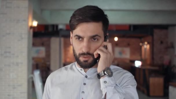 Facet z brodą rozmawia przez telefon. — Wideo stockowe