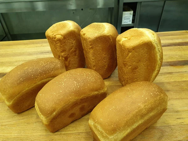 Tahta bir masada beyaz ekmek somunları