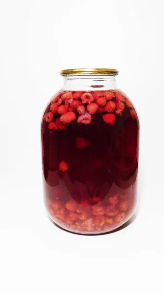 Beyaz arka planda üç litrelik bir kavanozda kiraz ezmesi.