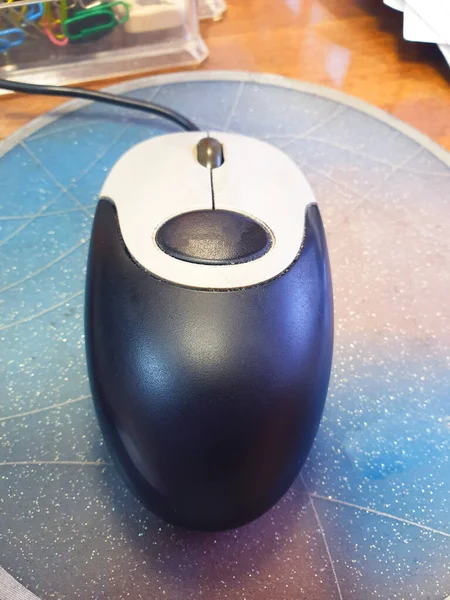 computer gray mouse with a wire on the rug view from the top