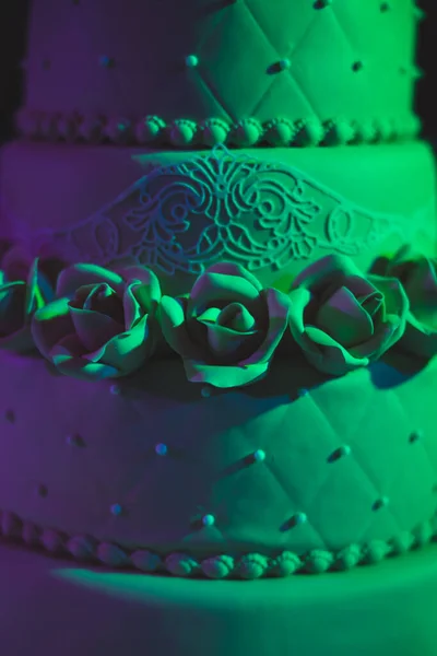 Egy gyönyörű barna háromrétegű esküvői torta rózsákkal. Ízletes látszó ünnepi torta. — Stock Fotó