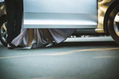 Yüksek topuklu bir kız arabadan iniyor. Kız ayakkabılarını kapat. Mezuniyet balosundaki yüksek topuklu bir kız. Şık giysi..