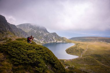 Fotoğrafçı Bulgaristan 'da doğa manzarasının fotoğrafını çekiyor. Rila göl yürüyüş yolu. Büyüleyici doğa dağı ve göl.